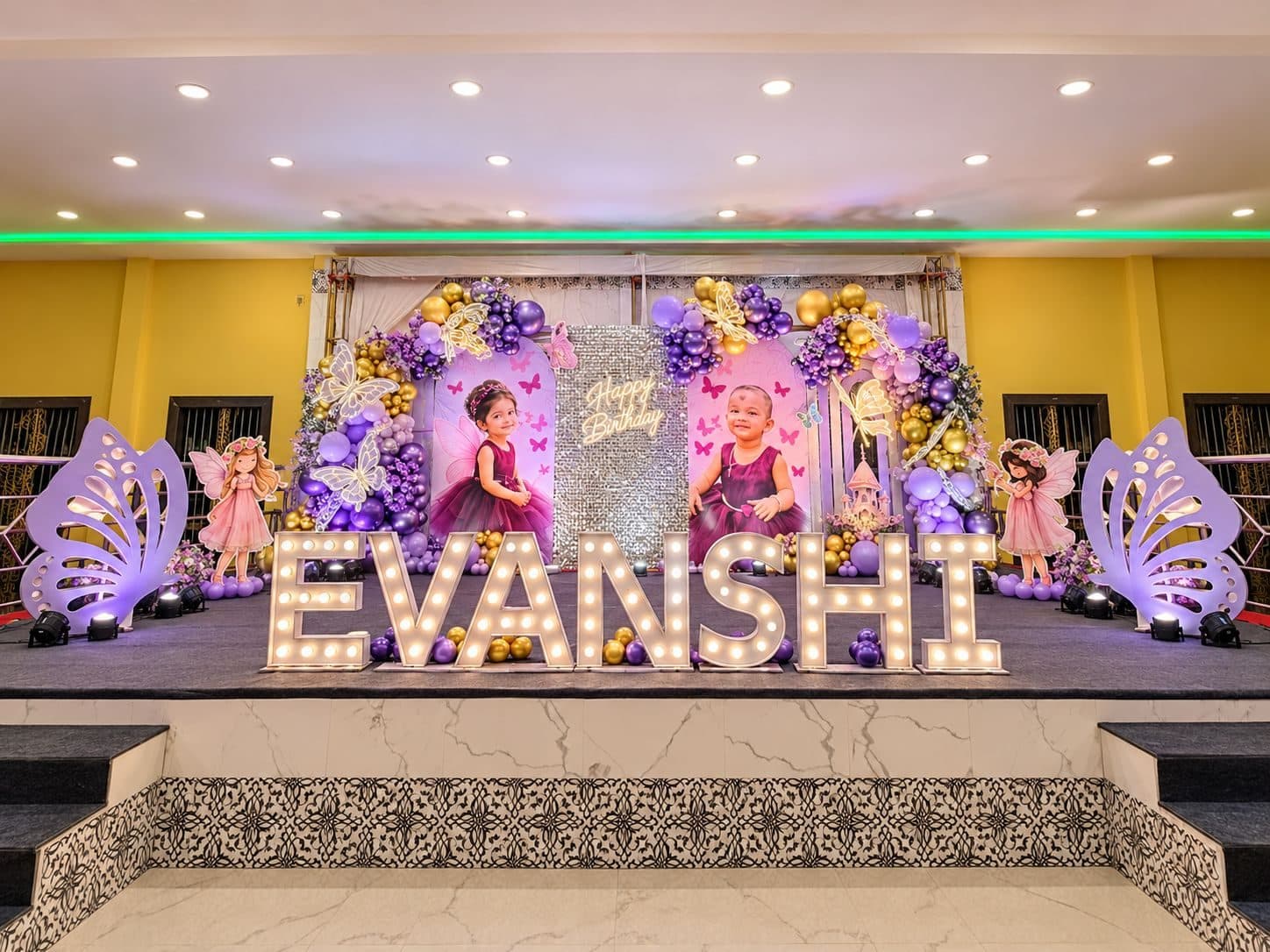 Purple fairy-themed birthday stage with illuminated marquee name letters