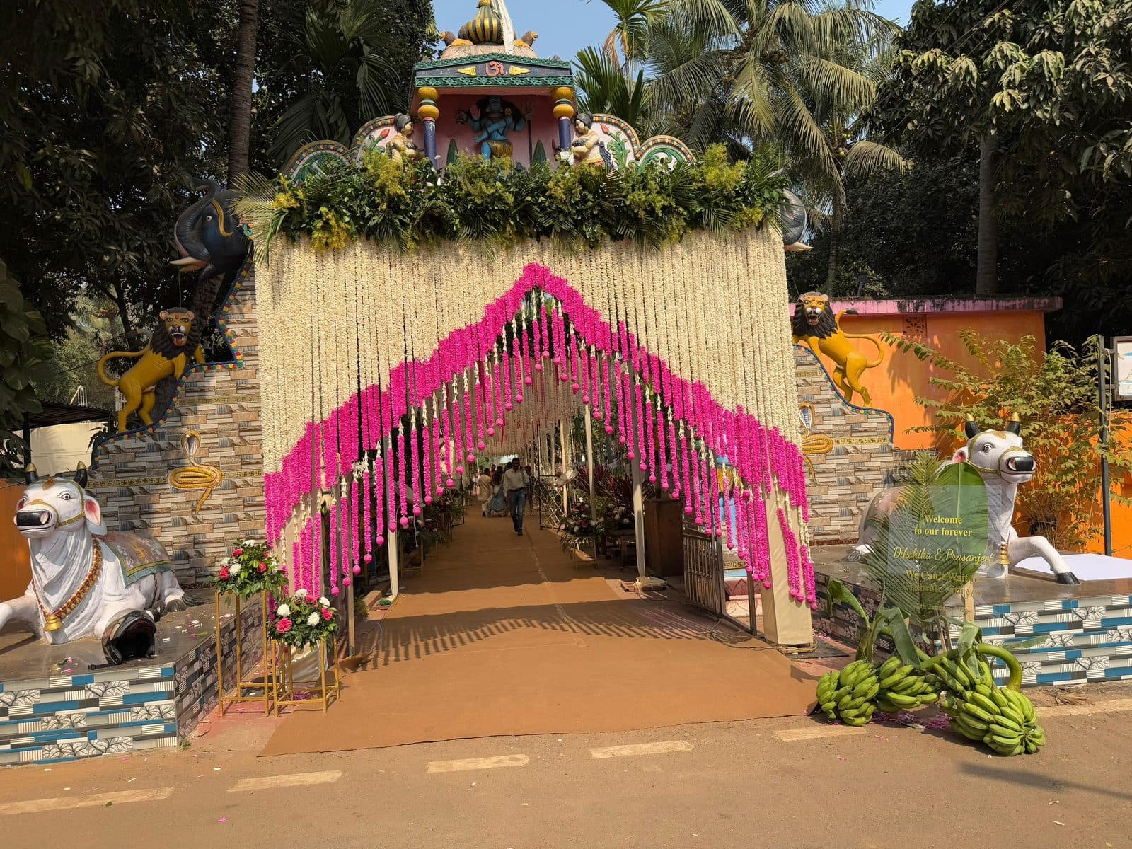 Grand temple wedding entrance draped in jasmine and pink flower garlands